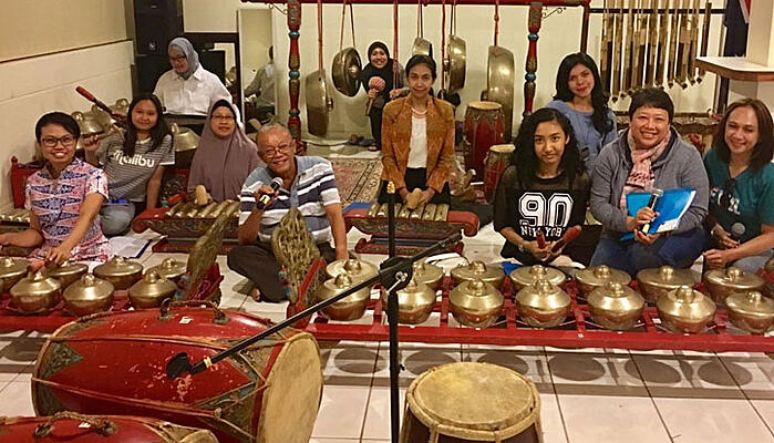 CDU student Dina Widyaputri Kariodimedjo and her research peers sit amongst Indonesian cultural artefacts