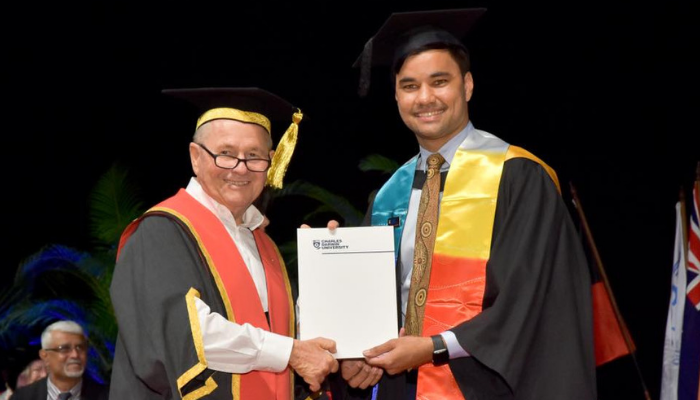 Mark Munnich holding his graduation certificate