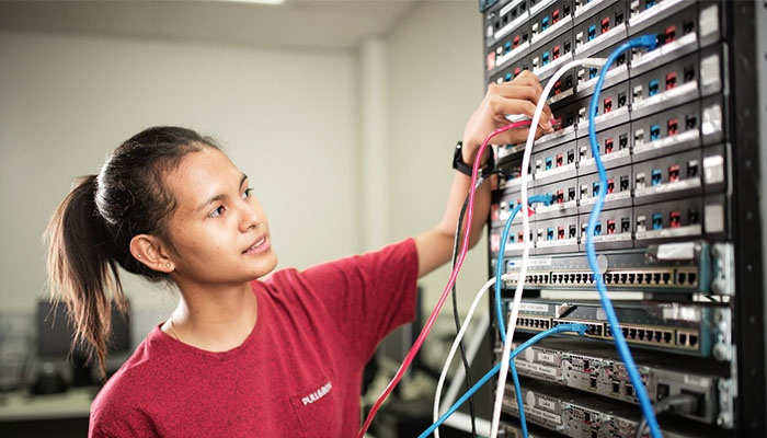 Female CDU IT student working on a switchboard