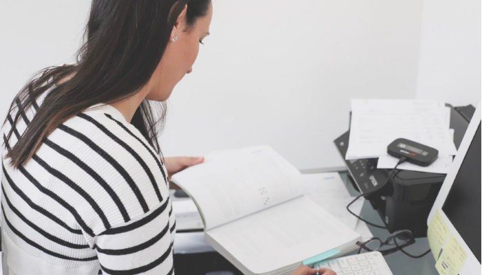 Sallie in her study space reading a textbook