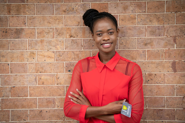 CDU nursing student Fifi Giraneza standing against a wall smiling