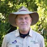 Will Kemp head and shoulders, wearing hat with green leaves in background