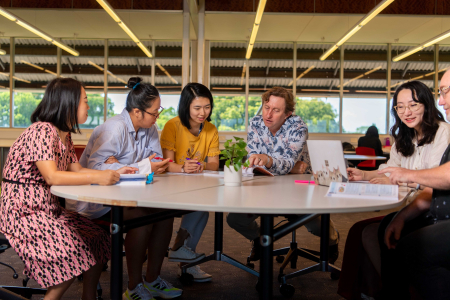 6 students sitting at a round table studying