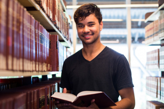 Mark in the library holding a book