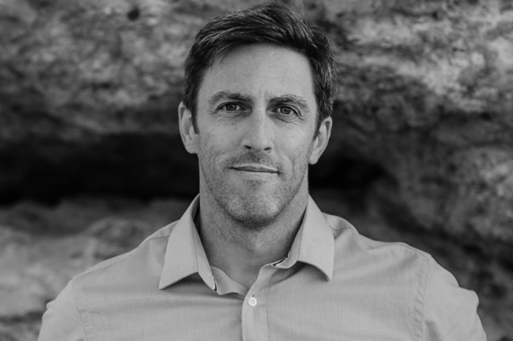 Author Russell Marks against rockface in black and white